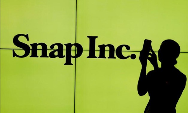 A woman stands in front of the logo of Snap Inc. on the floor of the New York Stock Exchange (NYSE) while waiting for Snap Inc. to post their IPO, in New York City, New York, U.S. on March 2, 2017.
Lucas Jackson/File Photo