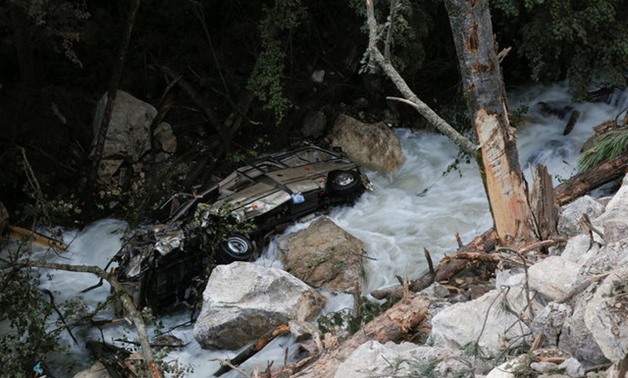 A car lies in a mountain creek beside a road that hit by a rockslide after an earthquake outside Jiuzhaigou - REUTERS