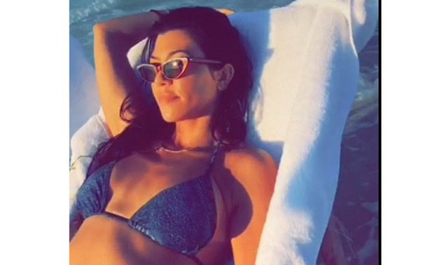 Kourtney Kardashian relaxing in a blue bikini and cat-eye sunglasses on the North Coast beach in Egypt - Instagram