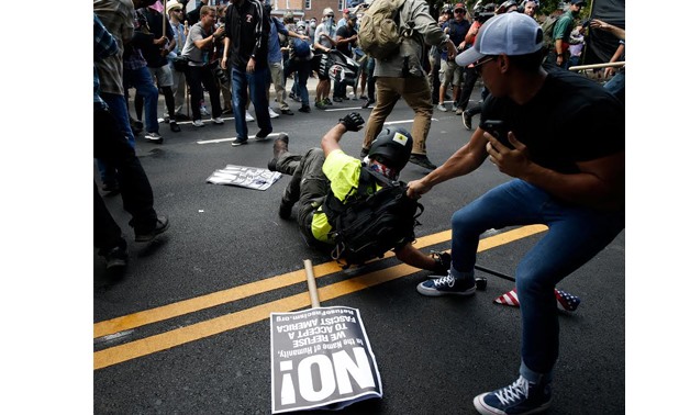 A man is pulled on after falling on the pavement during a clash between members of white nationalist protesters against a group of counter-protesters in Charlottesville, Virginia, U.S., August 12, 2017. REUTERS/Joshua Roberts