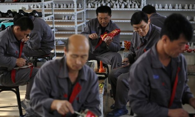 North Korean workers make soccer shoes inside a temporary factory at a rural village on the edge of Dandong, Liaoning province, China - Reuters