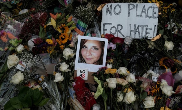 A photograph of Charlottesville victim Heyer is seen amongst flowers at the scene of the car attack on a group of protesters in Charlottesville - REUTERS