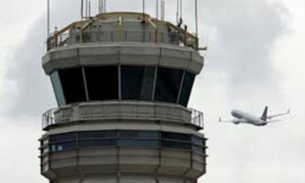 FILE PHOTO: A plane passes the air traffic control tower at Ronald Reagan Washington National Airport in Arlington, Virginia, U.S., June 5, 2017.
