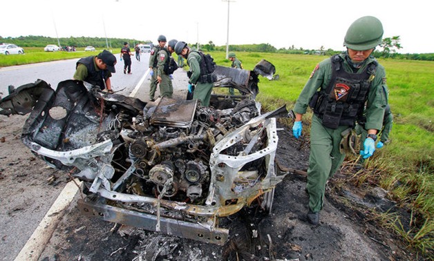 Military personnel search the site of a roadside bomb blast in the southern province of Pattani - REUTERS