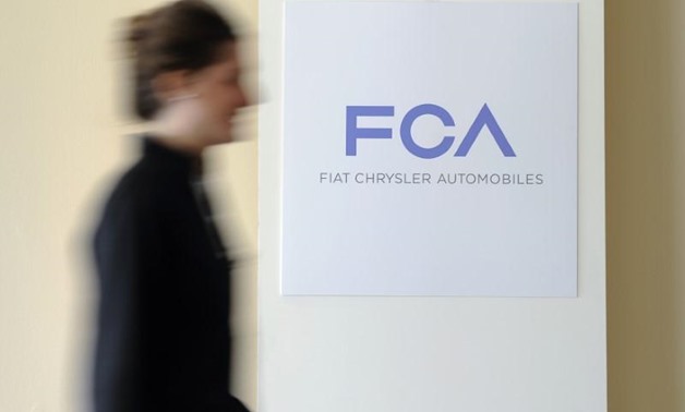 A woman walks past a logo of Fiat Chrysler Automobiles (FCA) in Turin March 31, 2014.
Giorgio Perottino