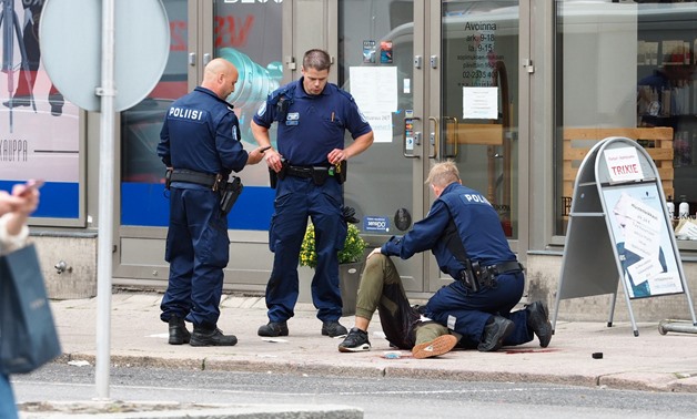 The suspect lies on the ground surrounded by police officers at the Market Square where several people were stabbed, in Turku, Finland August 18, 2017. Courtesy Kirsi Kanerva/Handout via REUTERS