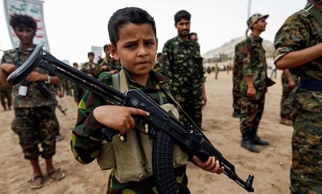 A Yemeni boy poses with a Kalashnikov assault rifle during a gathering of newly-recruited Huthi fighters in the capital Sanaa. A new UN report has flagged the vulnerability of children living in war zones -AFP