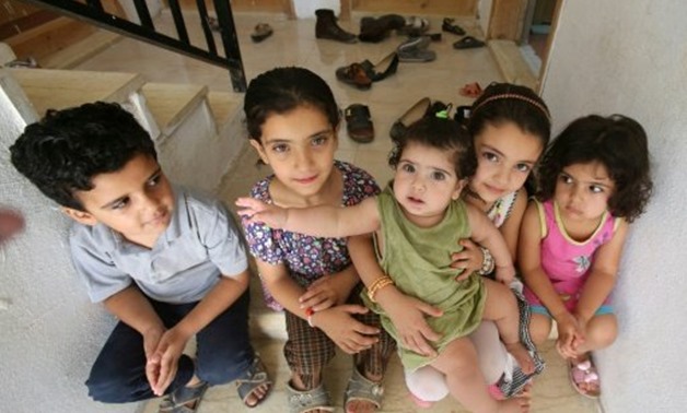© afp/AFP / by Mussa Hattar | The Ghazal children, Syrian refugees, sit on the steps outside their home in Jordan's Irbid on August 9, 2017