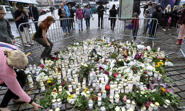 People bring memorial candles and flowers to the Turku Market Square for the victims of Friday's stabbings in Turku, Finland August 19, 2017. Lehtikuva/Vesa Moilanen via REUTERS ATTENTION EDITORS - THIS IMAGE WAS PROVIDED BY A THIRD PARTY. NO THIRD PARTY 