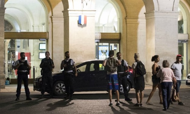  AFP | Passengers and police officers stand outside the train station of Nimes after it was reopened on August 20 