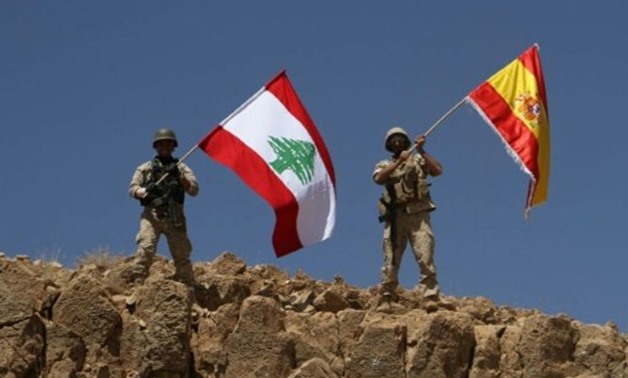 A handout picture released by the Lebanese army on August 19, 2017, shows Lebanese soldiers holding up the Lebanese and Spanish flags in Jurud Ras Baalbek, in solidarity with Spain after twin attacks claimed by the Islamic State group