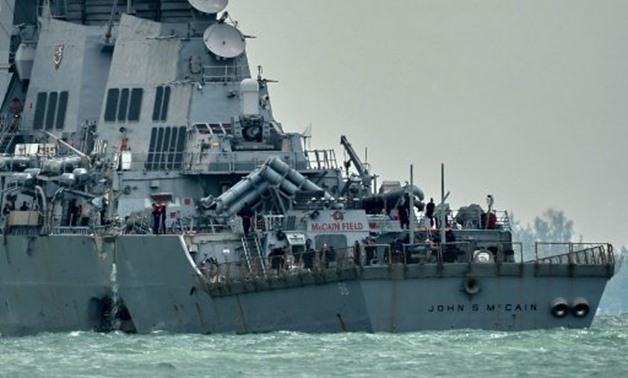 The guided-missile destroyer USS John S. McCain, with a hole on its portside after a collision with an oil tanker, makes its way to Changi naval base in Singapore