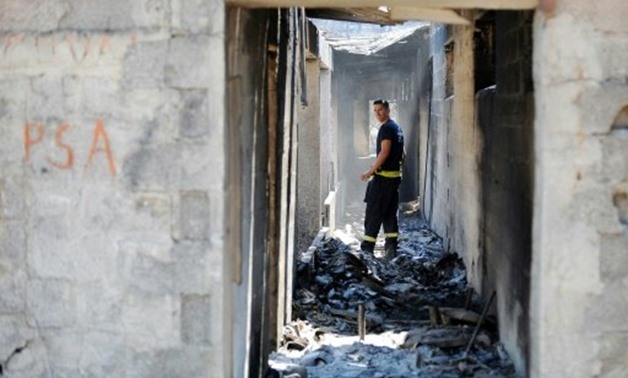 A firefighter walks in a burnt-out house in the village of Zrnovnica, near the Adriatic coastal town of Split in July 2017