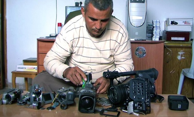 Emad Burnat with his cameras. Source: the film’s Facebook page