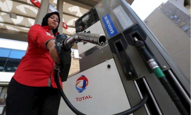 A female employee poses with a fuel pump at a petrol station in Cairo -Mohamed Abd El Ghany- Reuters
