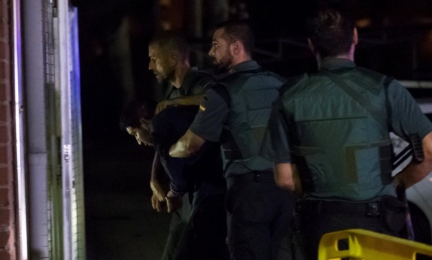 Spanish Civil Guards escort one of four men accused of involvement in an Islamist cell behind a van attack in Barcelona last week, in Tres Cantos