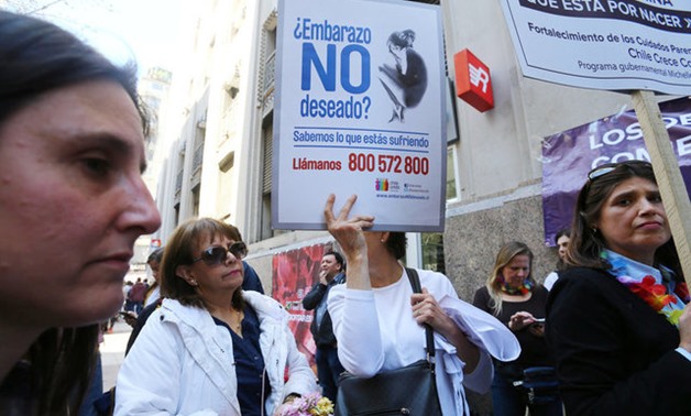 A demonstrator against abortion hold a placard during a rally in Santiago - REUTERS