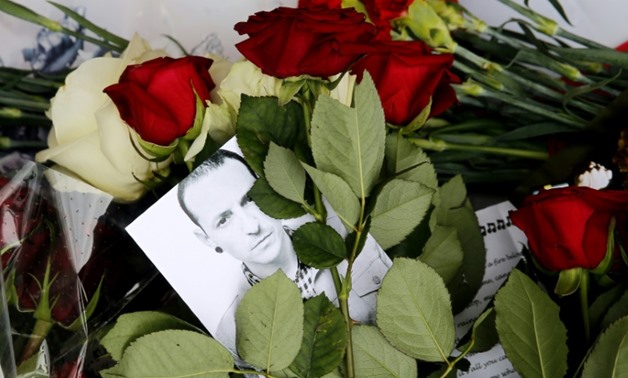 A picture taken on July 22, 2017 shows red roses and a picture of Linkin Park frontman Chester Bennington outside the US embassy in Moscow. He killed himself last month on the birthday of his late friend Chris Cornell of Soundgarden-AFP / Maxim ZMEYEV