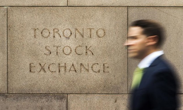 A man walks past an old Toronto Stock Exchange (TSX) sign in Toronto, June 23, 2014 - Reuters 