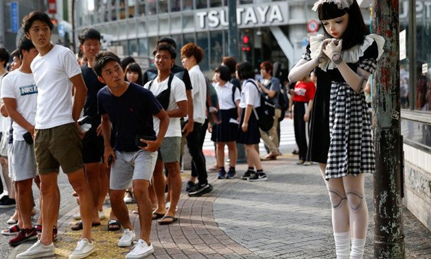 Pedestrians look at "doll" model Lulu Hashimoto standing on the street during a photo opportunity for Reuters in Tokyo, Japan August 23, 2017. Picture taken August 23, 2017.
Kim Kyung-Hoon