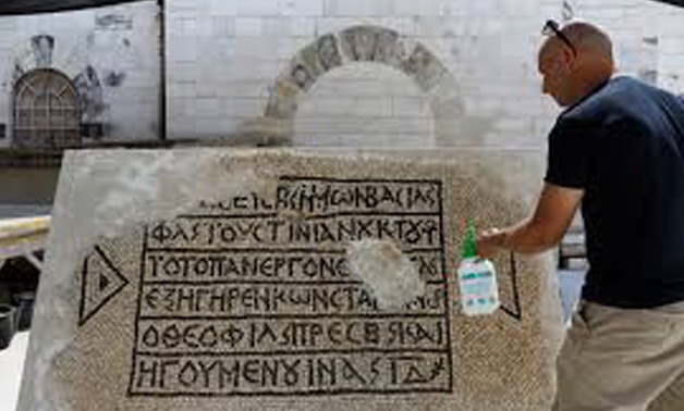 A conservationist works on a 1500-year-old mosaic floor bearing a Greek writing, discovered near Damascus Gate in Jerusalem's Old City, as it is displayed at the Rockefeller Museum in Jerusalem August 23, 2017.
Ronen Zvulun