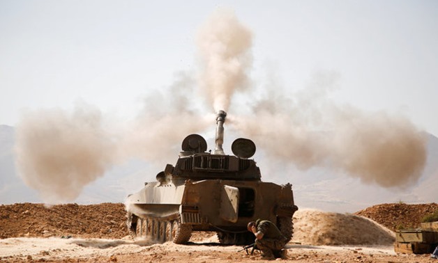 A Hezbollah fighter reacts as he fires a weapon in Western Qalamoun - REUTERS