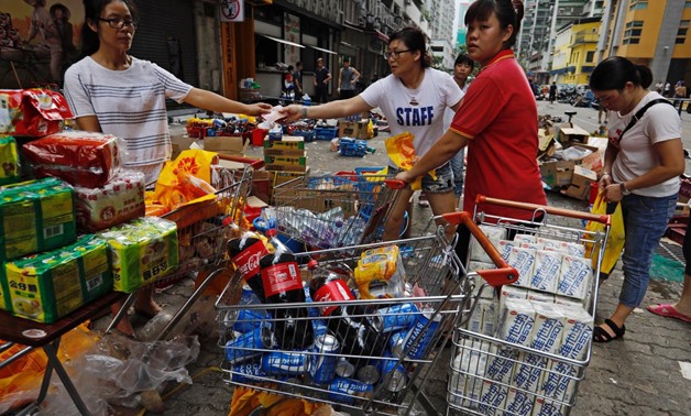 Supermarket staff sell goods outside a supermarket during power outages after Typhoon Hato hit in Macau, China August 24, 2017.
Tyrone Siu