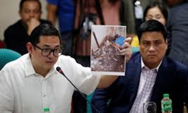 Senator Paolo Benigno Aquino IV holds a photograph of Kian Lloyd Delos Santos during a hearing on the killing of the 17-year-old high school student in a recent police raid, at the Senate headquarters in Pasay city, metro Manila, Philippines August 24, 20