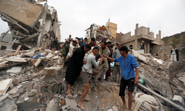 People carry the body of a woman they recovered from under the rubble of a house destroyed by a Saudi-led air strike in Sanaa, Yemen August 25, 2017. REUTERS