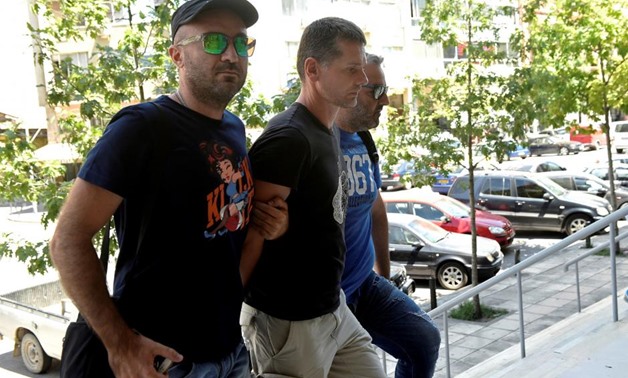 FILE PHOTO: Alexander Vinnik, a 38 year old Russian man (C) suspected of running a money laundering operation, is escorted by plain-clothes police officers to a court in Thessaloniki, Greece July 26, 2017.
Alexandros Avramidis/File Photo
