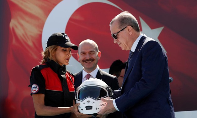 Turkish President Tayyip Erdogan, accompanied by Interior Minister Suleyman Soylu, receives a motorcycle helmet from a policewoman during a ceremony in Istanbul, Turkey, August 25, 2017.
Murad Sezer