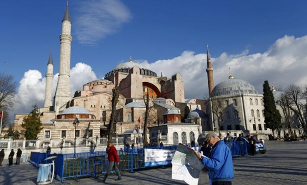 A tourist couple checks a map, near the Byzantine-era monument of Hagia Sophia, at Sultanahmet square in Istanbul,Turkey January 14, 2016