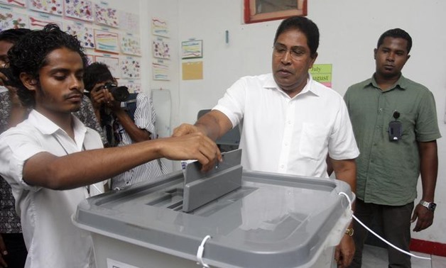 Maldivian Jumhooree Party presidential candidate Qasim Ibrahim (2nd R) casts his vote at a polling station during the presidential elections in Male, November 9, 2013 - REUTERS

