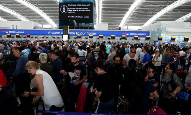People wait with their luggage at the British Airways check in desks at Heathrow Terminal 5 in London, Britain -REUTERSNeil Hall /File Photo
