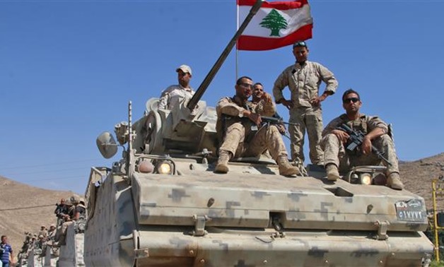 Lebanese Army soldiers sit atop an armored personnel carrier as they drive in the eastern town - CC
