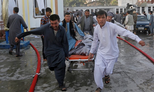 Afghan men carry a dead body on a stretcher from the site of a suicide attack followed by a clash between Afghan forces and insurgents after an attack on a Shi'ite Muslim mosque in Kabul, Afghanistan, August 25, 2017. REUTERS/Omar Sobhani