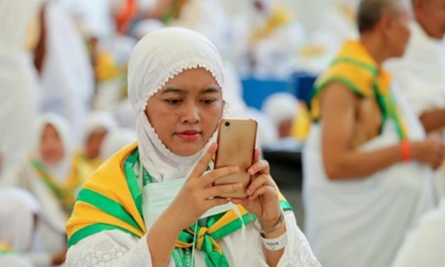 © AFP / by Nadera Bouazza | A pilgrim uses her cellphone on arrival at Jeddah airport on August 26, 2017, ahead of the annual hajj pilgrimage