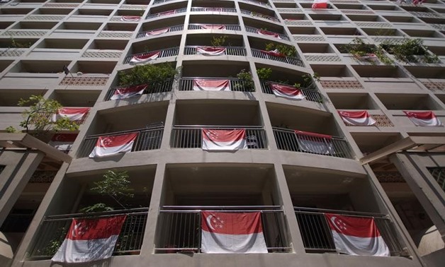 FILE PHOTO: Singapore's national flags are displayed from an apartment block during National Day in central Singapore August 9, 2011.
Kevin Lam