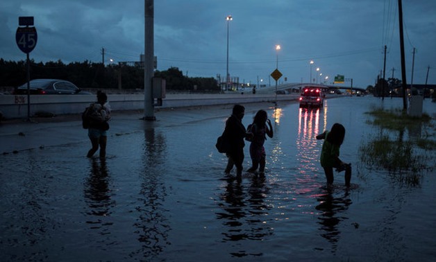 Members of the Duong family walk through flood waters from Tropical Storm Harvey on the feeder road of Interstate 45 in Houston, Texas, U.S. August 27, 2017. REUTERS/Adrees Latif TPX IMAGES OF THE DAY TPX IMAGES OF THE DAY

