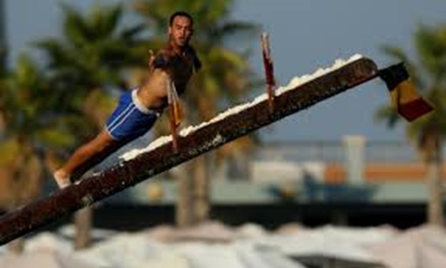 A competitor tries to grab a flag as he falls off the "gostra", a wooden pole covered in lard, during the main competition, part of the celebrations on the religious feast day of St Julian, patron of the town of St Julian's, Malta, August 27, 2017.
Darri