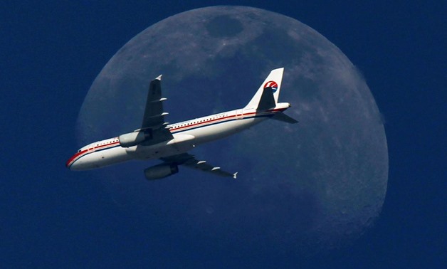 FILE PHOTO - A China Eastern Airlines passenger jet passes in front of the moon over Shanghai May 13, 2011.
Aly Song/File Photo