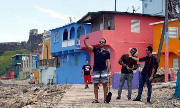 A man takes a selfie with friends in La Perla area where the video for "Despacito" was recorded in San Juan - AFP
