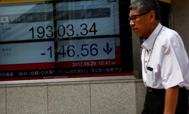 A man walks past an electronic board showing Japan's Nikkei average outside a brokerage at a business district.
REUTERS-Kim Kyung-Hoon