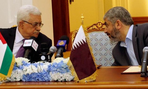 Palestinian President Mahmoud Abbas (L) and Hamas leader Khaled Meshal talk before signing ceremony for an agreement in Doha February 6, 2012 - Reuters 