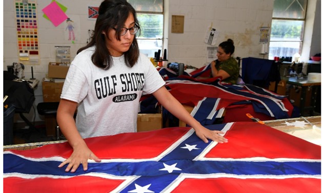 Cynthia Hernandez places stars on a Confederate Battle Flag in the Alabama Flag & Banner shop in Huntsville, Alabama, U.S.