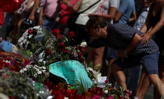 A man places flowers at an impromptu memorial where a van crashed into pedestrians at Las Ramblas in Barcelona