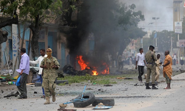 Somali government soldiers stand at the scene of an explosion in Maka al-Mukara streets in Mogadishu - REUTERS