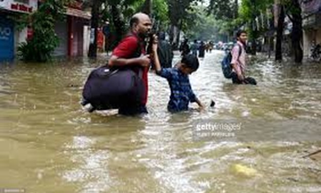 © Punit Paranjpe, AFP | Indians wade through a flooded street during heavy rain showers in Mumbai on August 29, 2017.
