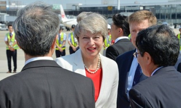 British Prime Minister Theresa May is greeted by Japanese officials upon her arrival at Otami airport in Osaka on August 30, 2017