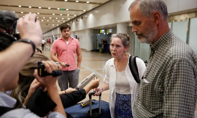 Aid workers Heidi Linton (2nd R) and Rob Robinson (R) of Christian Friends of Korea talk to the media after their arrival from Pyongyang at Beijing airport